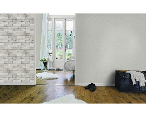 Pièce lumineuse avec papier peint imitation briques, parquet et vue sur un jardin