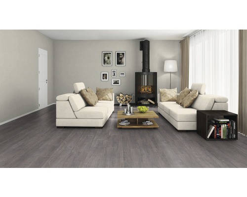 Salon avec revêtement de sol gris, cheminée et canapés blancs.