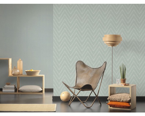 Wohnzimmer mit Zickzacktapete, Sessel und Regalen.