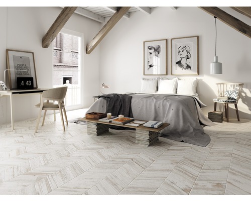 Heller Schlafraum im Dachgeschoss mit Bett, Schreibtisch und Holzbalken