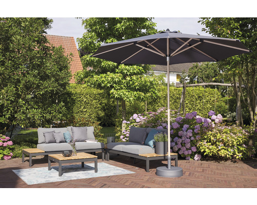 Salon de jardin sous un parasol sur une terrasse en brique