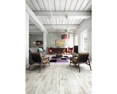 Heller Wohnraum mit Holzboden, Sofa, Sesseln und Dekoration