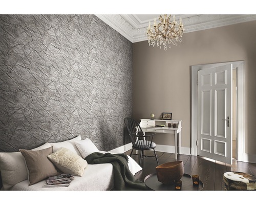 Wohnzimmer mit Couch, Schreibtisch und gemusterter Tapete