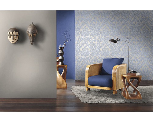 Salon avec papier peint à motifs floraux, fauteuil et masques décoratifs en bois