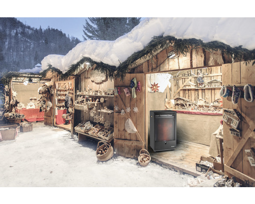 Marché d''hiver avec des cabanes en bois, décorées d''ornements de Noël et illuminées, et un radiateur.