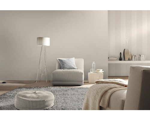 Salon avec fauteuil, lampadaire, tapis et éléments décoratifs dans des tons neutres.