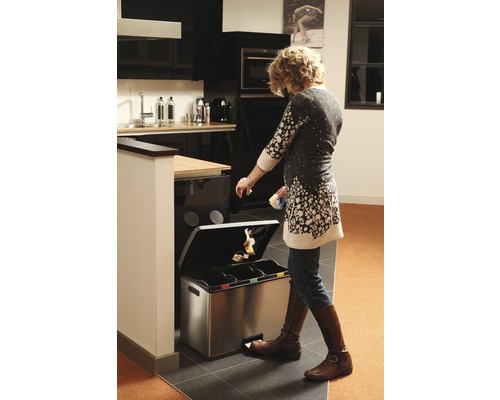 Femme utilisant un système de tri des déchets dans la cuisine