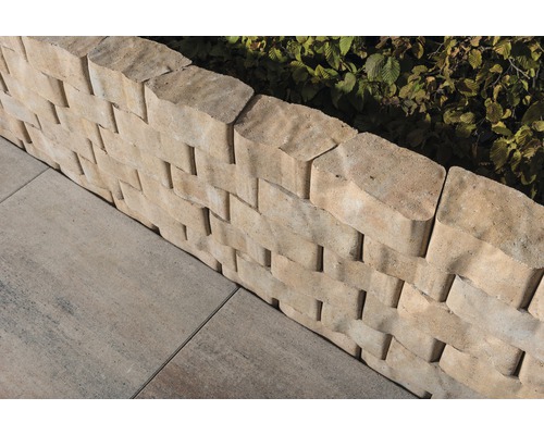 Vue détaillée d''un mur de soutènement en pierres bétonnées avec des pavés dans le jardin