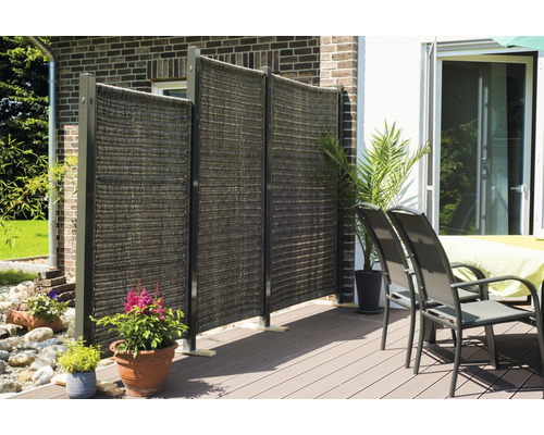 Terrassenszene mit Sichtschutzelementen, Gartenmöbeln und Pflanzen