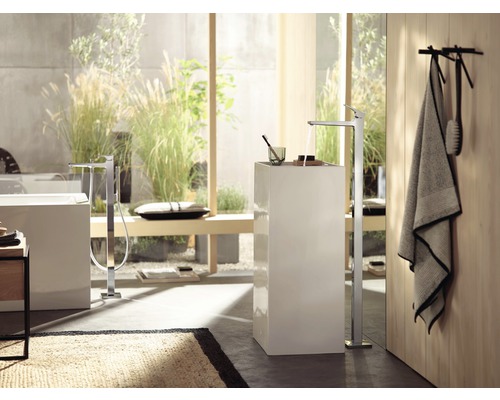 Badezimmer mit freistehender Badewannenarmatur und Handtuch