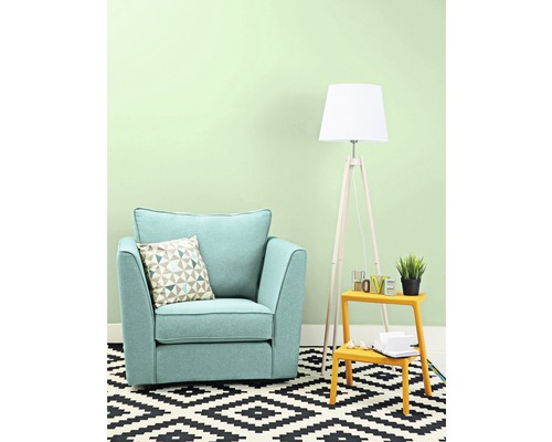 Wohnzimmer mit Sessel, Kissen, Stehlampe und Teppich mit geometrischem Muster