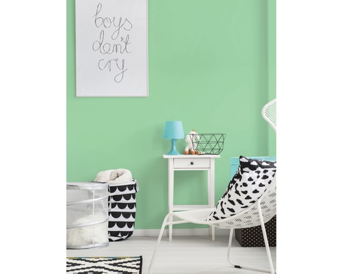 Heller Raum mit mintgrüner Wandfarbe, dekoriert mit weißem Stuhl, Nachttisch und Korb