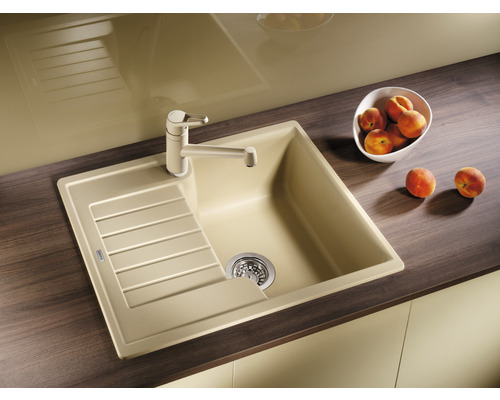 Évier avec égouttoir et robinet sur un plan de cuisine.