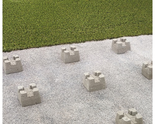 Szene mit Beton-Rasenkantensteinen auf Kiesfläche neben Rasen