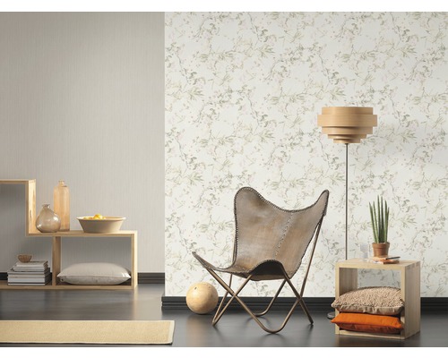 Wohnraum mit gemusterter Tapete, Sessel und Regalen
