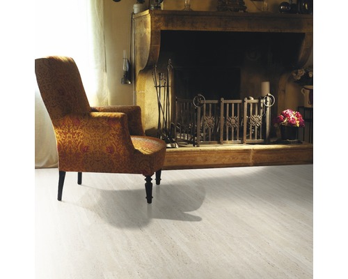 Salon avec fauteuil, cheminée et revêtement de sol clair.