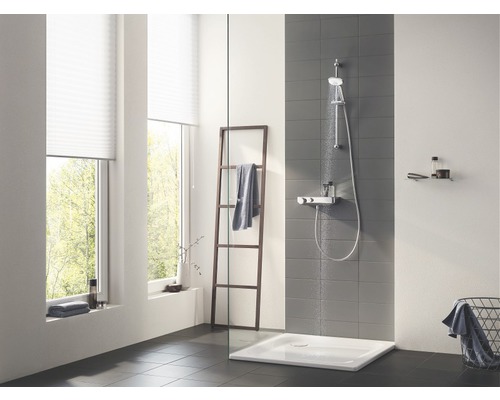 Salle de bains lumineuse avec douche, échelle à serviettes et fenêtre