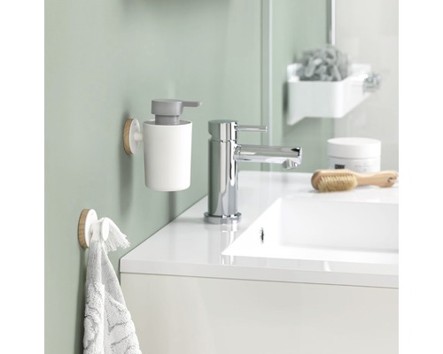 Salle de bain moderne avec distributeur de savon, porte-serviettes et lavabo