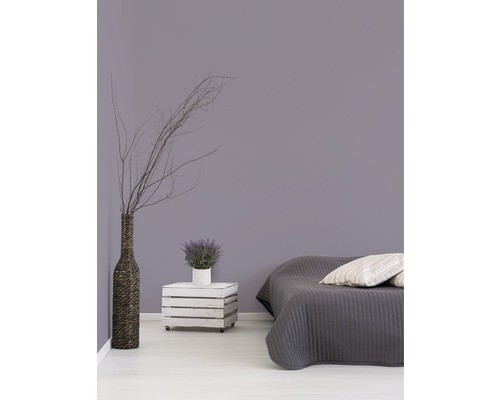 Schlafzimmer mit Bett, Holzkiste auf Rollen als Nachttisch, Vase und Dekoration