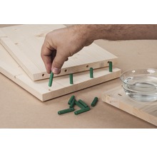 Des planches de bois avec des chevilles sont assemblées.