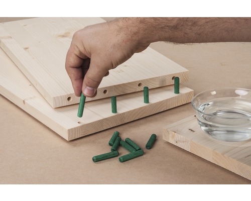 Des planches de bois avec des chevilles sont assemblées.