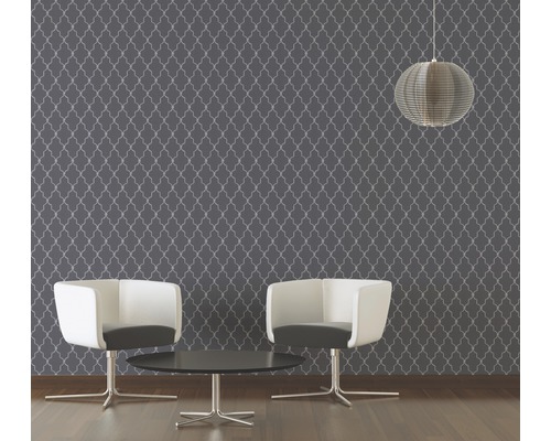 Raum mit gemusterter Tapete, zwei Stühlen und einer Hängelampe