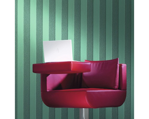 Scène avec un ordinateur portable sur un fauteuil rouge devant un papier peint rayé