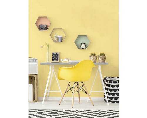 Helles Arbeitszimmer mit Schreibtisch, gelbem Stuhl und dekorativen Regalen