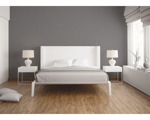 Helles Schlafzimmer mit weißem Bett, Nachttischen und Lampen auf Holzboden
