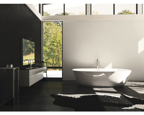 Salle de bain moderne avec baignoire îlot, meuble-lavabo et grande fenêtre.