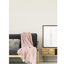Wohnzimmer mit Sofa, Kissen, Decke und Beistelltisch mit Bilderrahmen