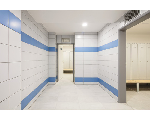 Flur mit Fliesenwänden und Spindraum im Hintergrund