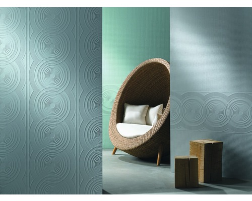 Szene mit geprägten Wandfliesen mit Kreisdesign und einem Korbsessel mit Kissen.