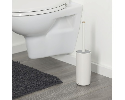 WC suspendu avec brosse de toilette et tapis de bain