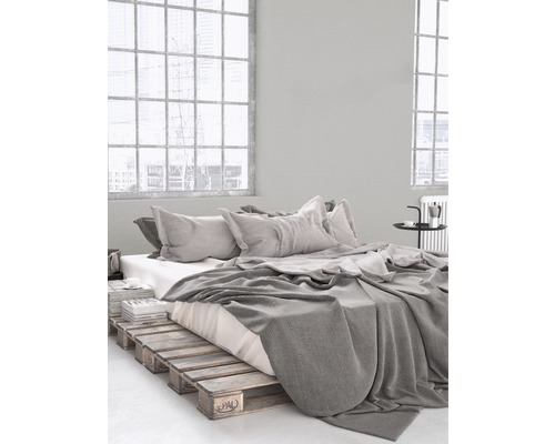 Schlafzimmer mit Bettgestell aus Holzpaletten, Bettwäsche und Kissen