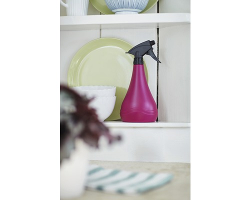 Sprühflasche aus Kunststoff auf einem Regal mit Geschirr