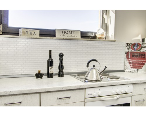 Scène de cuisine avec mur carrelé, cuisinière et décoration