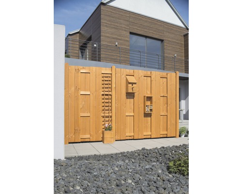 Gartenzaun aus Holz mit integriertem Rankgitter, Vogelhaus und Insektenhotel vor einem modernen Haus