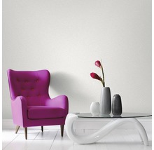 Zimmer mit Sessel, Tisch und Tapete an der Wand