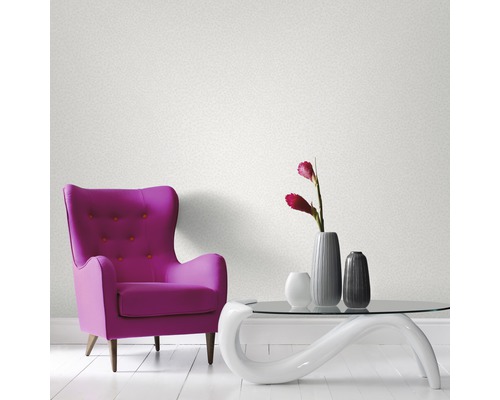 Zimmer mit Sessel, Tisch und Tapete an der Wand