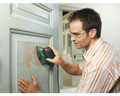 Mann schleift eine Tür mit einem Schwingschleifer der Marke Bosch