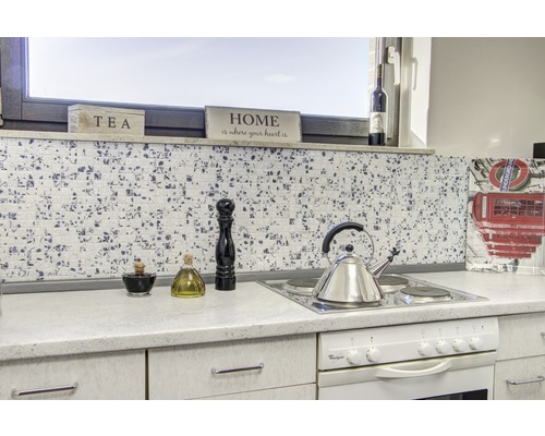 Scène de cuisine avec des carreaux de mosaïque, une plaque de cuisson, une bouilloire et des ustensiles de cuisine