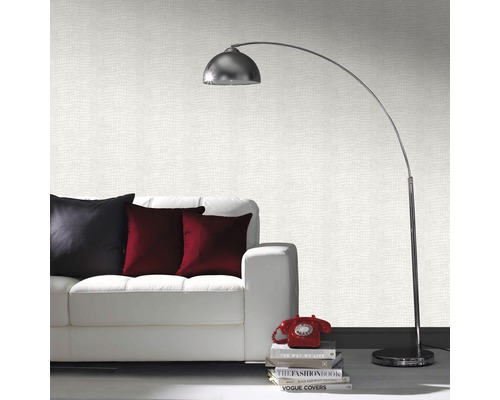 Wohnzimmer mit weißem Sofa, Kissen, Stehlampe und gemusterter Tapete