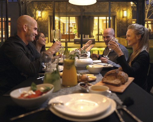 Gruppe von Menschen sitzt an einem gedeckten Tisch bei einem Abendessen