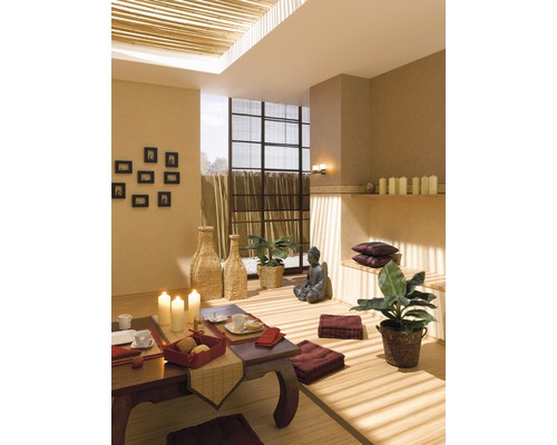 Pièce aménagée de style asiatique avec table, coussins de sol et statue de Bouddha.