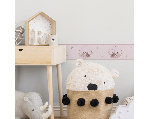 Chambre d''enfant avec papier peint à motifs, table de chevet et jouets