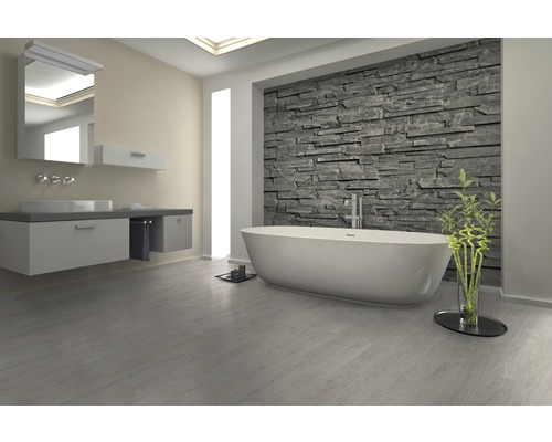 Salle de bains avec baignoire, lavabo et mur en pierre