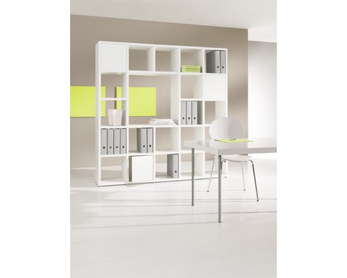 Étagère blanche avec compartiments pour ranger des classeurs et des livres dans un bureau.