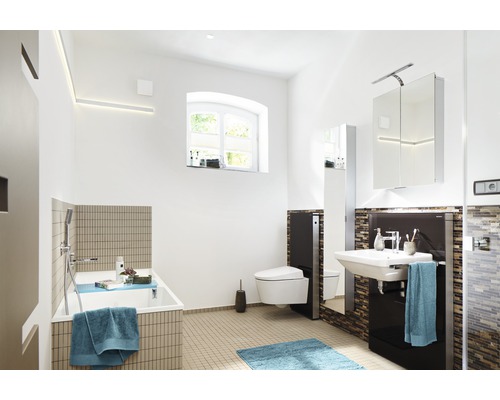 Salle de bains lumineuse avec baignoire, toilettes, lavabo et armoire de toilette