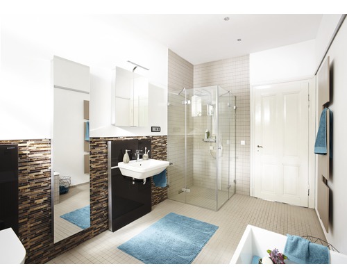 Salle de bains avec douche, lavabo, armoire de toilette et tapis de bain bleu